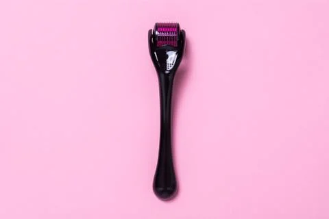 Derma roller on a pink background. The device for cosmetic procedures of meso Stock Photos