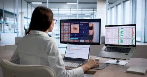 Dermatologist Examines Mole On Computer Screen To Diagnose Skin Cancer Risk. Stock Photos