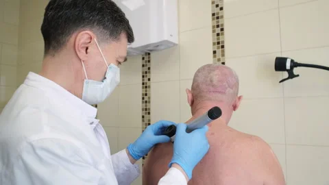 A dermatologist examines the patient's skin using a dermatoscope. Stock Footage 249667592