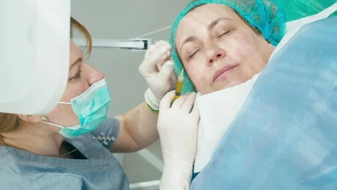 A dermatologist injects plasma under the client's skin, providing rejuvenation. Stock Footage 276872925