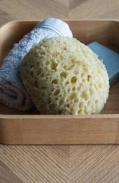 Dermo Aqua soft bath sponge on a wooden background Foto stock