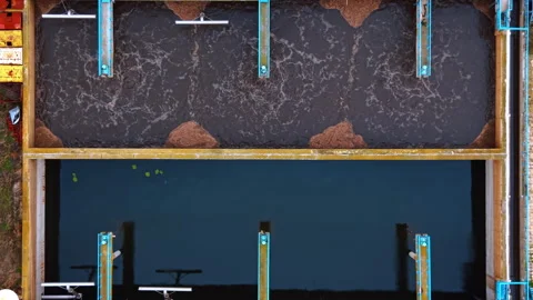 Descend over two rectangular reservoirs with bubbling and calm water. Sewage 스톡 동영상 330367061