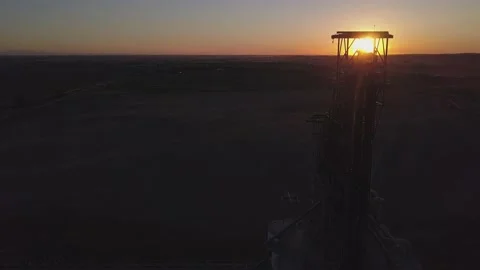 Descending aerial of backlit grain elevator silo on Alberta prairie Stock Footage 155956393