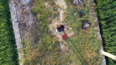 Descending aerial top down view of hijabi woman stretching at green rice field. 스톡 동영상 341540076