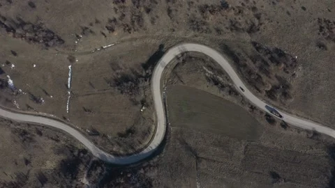 Descending on curvy road while car is passing 4K drone video Stock Footage 101014724