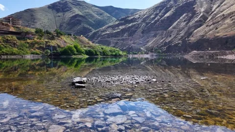 Descending Drone Shot Over Riverside with Anglers and Stone Skipping Stock Footage 340202715