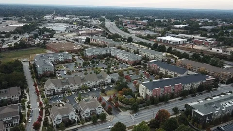 Descending drone shot overlooking condo community and traffic Stockbeeldmateriaal 100618459