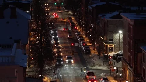 Descending drone view over snowy American downtown street at night, with busy Stock Footage 334259243