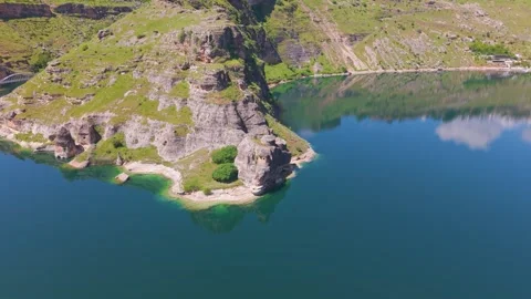 Descending Flight Toward Ancient Lakeside Rock Formations with a Smooth Left Stock-Footage 341079261