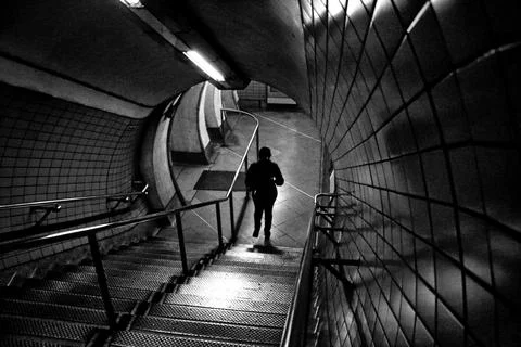 Descending one step at time in a dark tunnel. Stock Photos