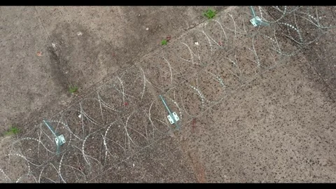 Descending Top-Down Push Toward Razor Wire Mounting Bracket Stock-Footage 344118688