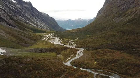 Descending Towards a Glacial River Surrounded by Pristine Wilderness Stock Footage 83477438