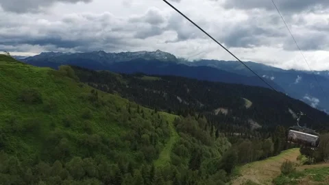 Descent on a cable car. View from the ski lift in the mountains to the green Stock Footage 143076916
