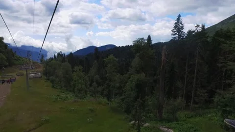 Descent on a cable car. View from the ski lift in the mountains to the green Stock Footage 157341132