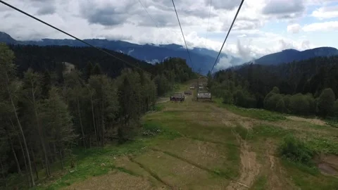 Descent on a cable car. View from the ski lift in the mountains to the green Stock Footage 161600504