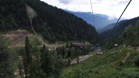 Descent on a cable car. View from the ski lift in the mountains to the green Stock Footage 166118022