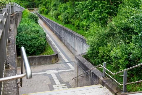 Descent into the underground passage. steps down with iron handrails Foto stock