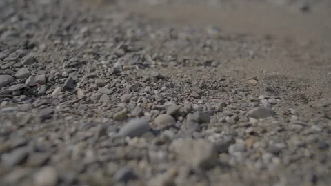 Describing a rocky beach, highlighting sandy textures, rough rocks, and Stock Footage 280331408