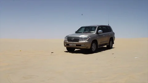 Desert 4x4 SUV Appears Over Sand Dunes in Qatar Desert Stock Footage 105993803