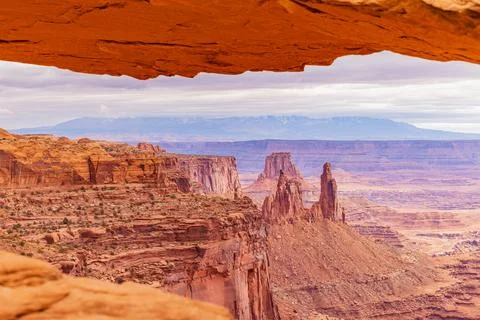 Desert arch frame captures distant sandstone towers Stock-Fotos