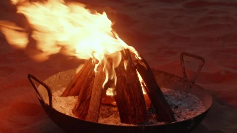 Desert campfire with glowing lanterns and chairs at night, cozy camping Stock Footage 327896097