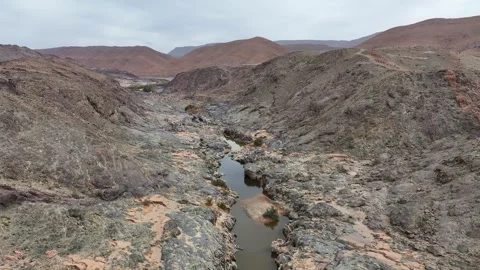 Desert Canyon with Narrow Stream Winding Through Rocky Terrain Stock Footage 336618012