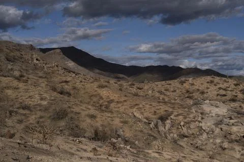 Desert with clouds over mountain Stock Photos