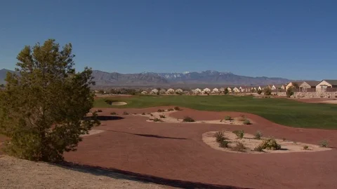Desert golf course running along a neighborhood and mountains Stock Footage 125343780