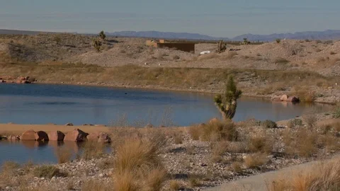 Desert golf course surrounded by water and mountains and cactus Stock Footage 125343787