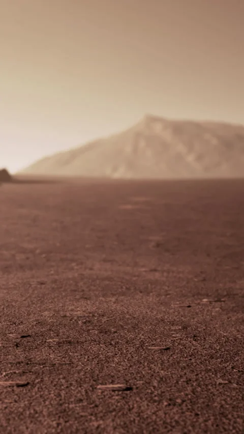 Desert landscape with dry ground and distant mountains under clear sky Stock Footage 338420289