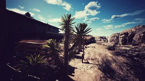 Desert landscape featuring cacti and rustic buildings under a bright sky Ilustración de archivo