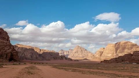 Desert landscape, red sand and rocks. Clouds and shadows move fast Stock Footage 109100705