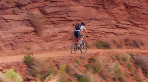 Desert Mountain Biking down Dirt Trail Stock Footage 25213455