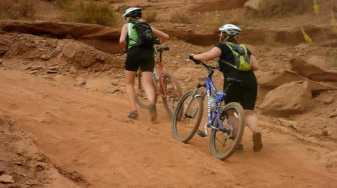 Desert Mountain Biking Pushing Bikes up Big Hill Video stock 25216103
