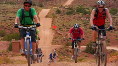 Desert Mountain Biking Riders Coming up Road Telephoto Stock Footage 25208433