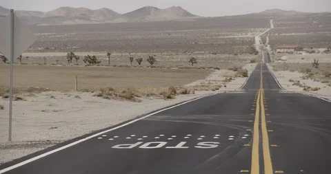 Desert Road with Joshua Tree and House in Distance - Stop in Foreground - Pan Stock Footage 89942072