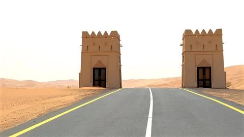 Desert road leading between two majestic gate towers in Arabic oriental style Stock Photos