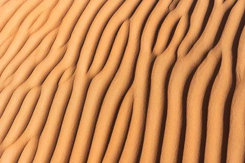 Desert sand dune patterns creating abstract ripple texture in oman Stock Photos