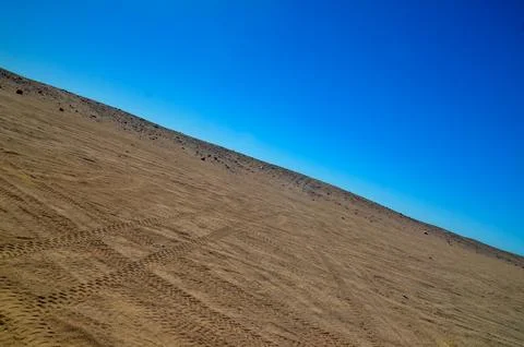 Desert sand dune under clear blue sky Stock Photos