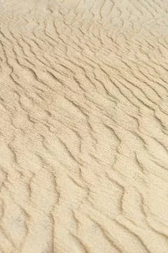 Desert sand dunes texture. Waves on the yellow sands of the desert. Close-up of Stock Photos