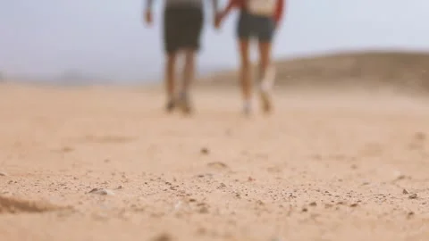 Desert sand in focus with blurred couple walking in background Stock Footage 332015207
