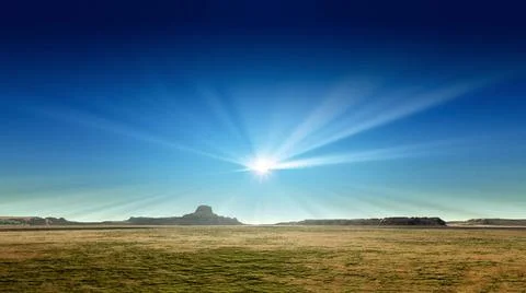 A desert scenery with sun rays in the blue sky 3d rendering of a desert sc... Stock Photos