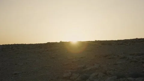 Desert sun sets behind rocky hill Vídeo Stock 339074851