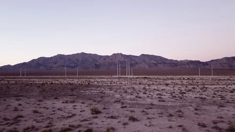 Desert terrain flyover towards power lines Stock Footage 81574871