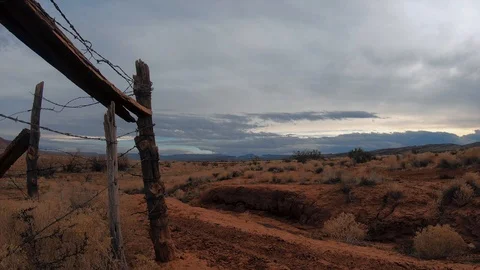 Desert time-lapse, clouds moving slowly, desert sunset, wooden fence post Stock Footage 123003919