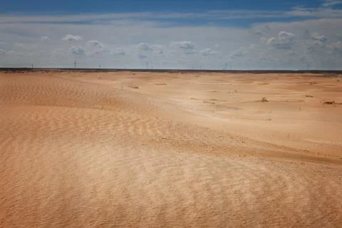 Desert under a blue sky with clouds Stock Photos