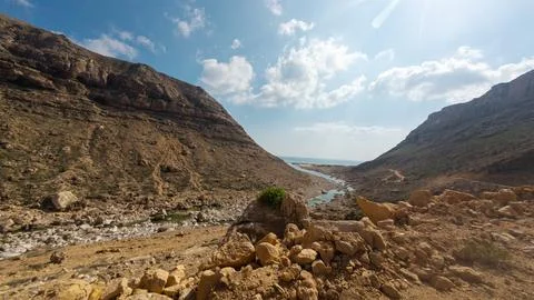 Desert valley with river between rocky mountains Foto stock