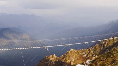 Deserted alpine suspension bridge on a background of rocky mountains. Stock Footage 107031579