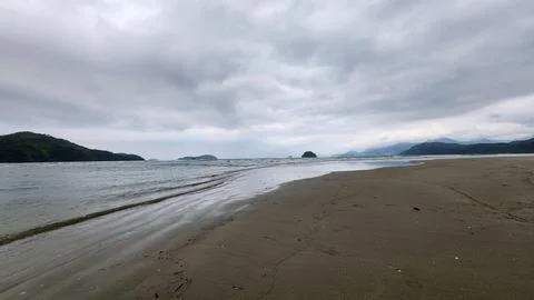 Deserted beach on a cloudy day Stock Photos