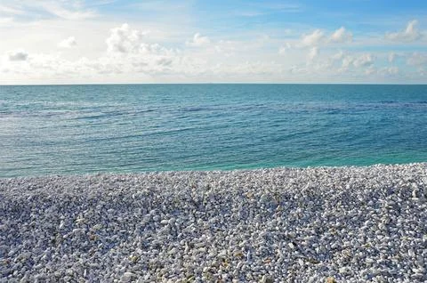 A deserted beach with small pebbles of various sizes Stock Photos